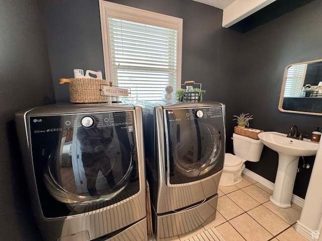 1844 W Heritage Ranch Dr N, Farr West, UT 84404 - laundry room featuring washing machine and dryer, baseboards, light tile patterned flooring, and laundry area