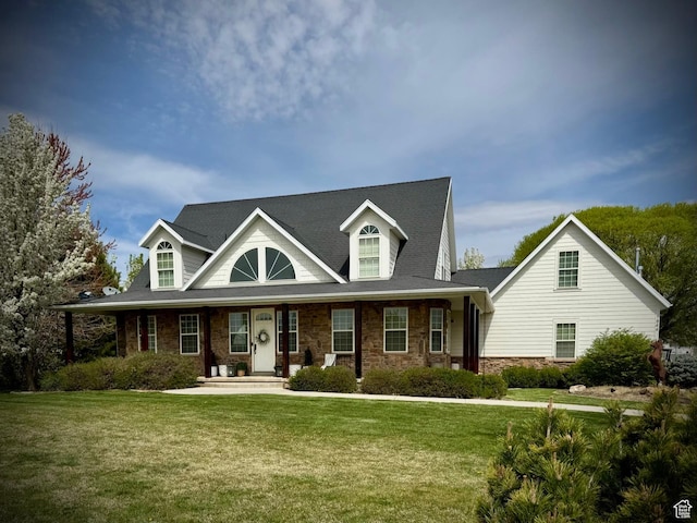 cape cod home featuring a front lawn, a porch, and stone siding