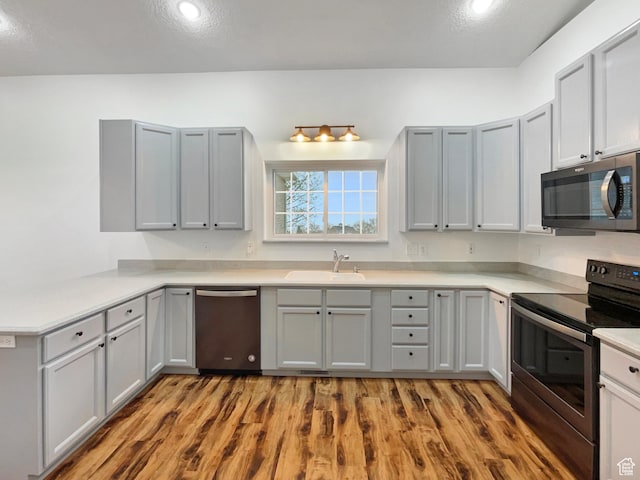 112 E Ama Fille Ln, Payson, UT 84651 - kitchen with stainless steel appliances, a sink, gray cabinetry, wood finished floors, and light countertops