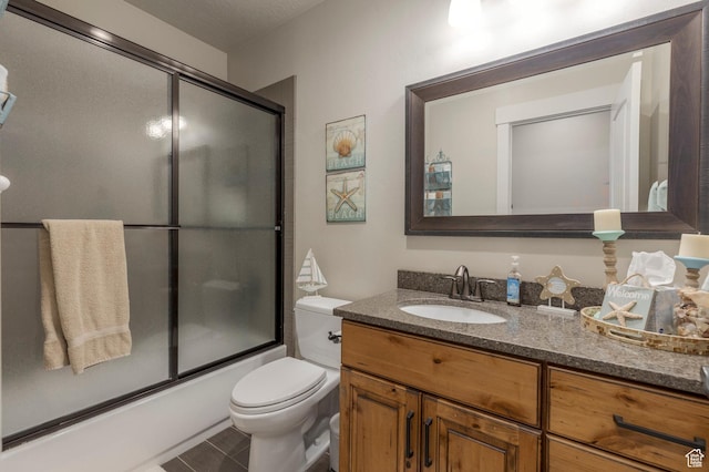 bathroom with vanity, shower / bath combination with glass door, and toilet