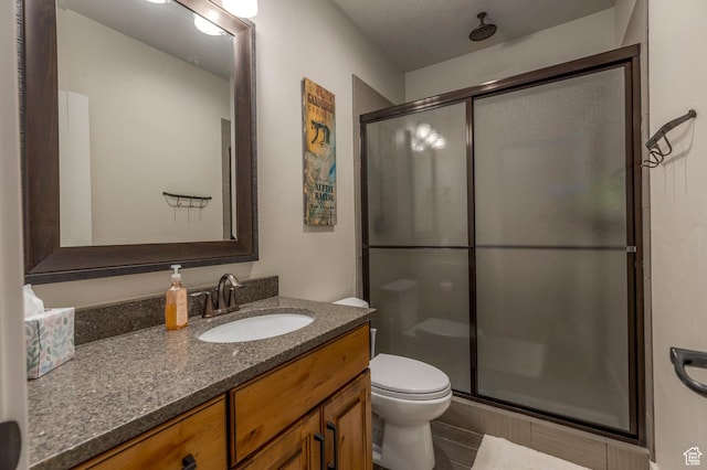 full bathroom with a shower stall, toilet, and vanity