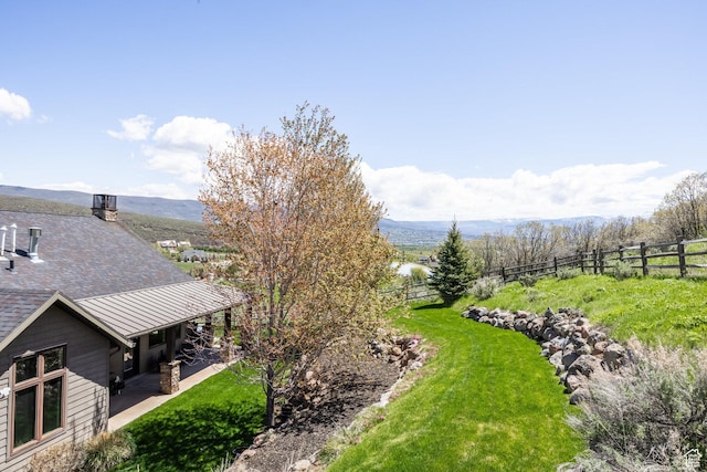 view of yard featuring fence, a patio, and a mountain view