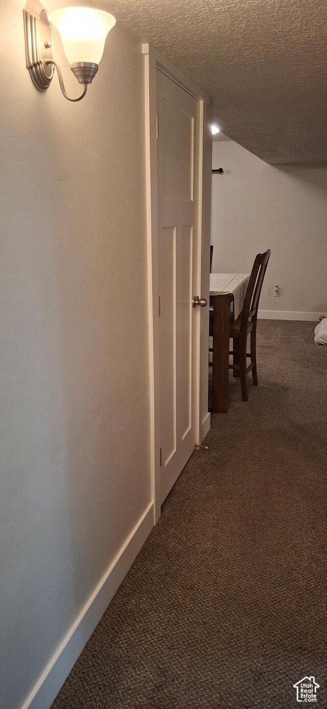 4502 S Stonington Way, Taylorsville, UT 84129 - hallway featuring dark carpet, baseboards, and a textured ceiling