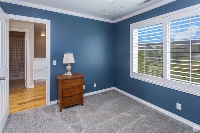 carpeted bedroom with baseboards, ornamental molding, and visible vents