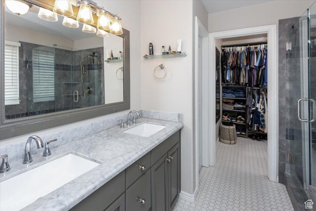 full bath featuring a walk in closet, a stall shower, and a sink