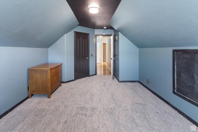 bonus room featuring a textured ceiling, carpet flooring, and baseboards