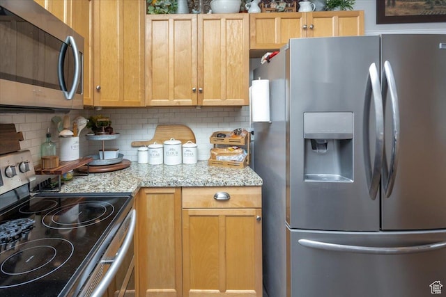 kitchen featuring decorative backsplash, light stone counters, and appliances with stainless steel finishes
