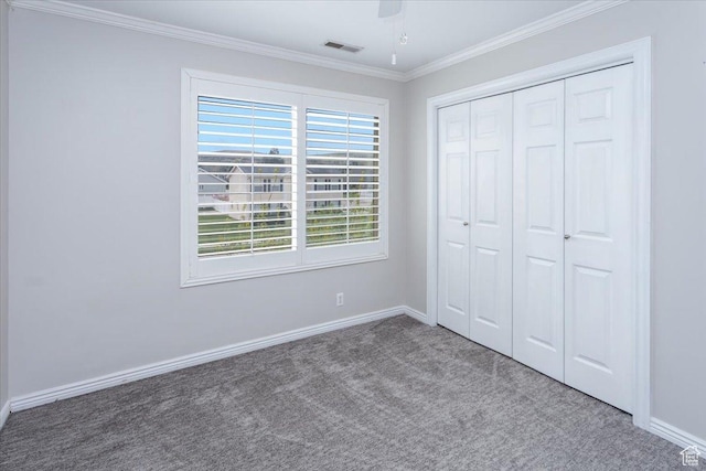 unfurnished bedroom featuring baseboards, ornamental molding, visible vents, and carpet