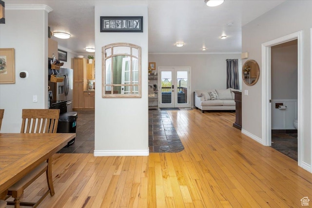 entrance foyer with light wood-style floors, crown molding, and baseboards
