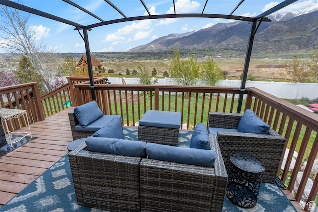 deck featuring a fenced backyard, a mountain view, a playground, a yard, and an outdoor living space