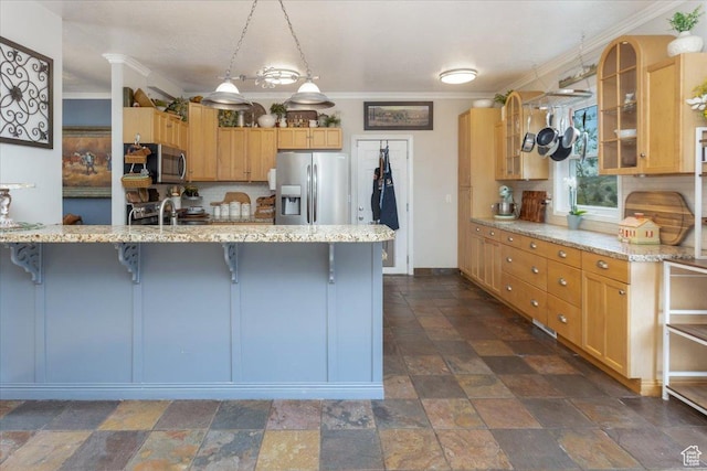 kitchen with decorative backsplash, stone tile floors, a breakfast bar, appliances with stainless steel finishes, and ornamental molding