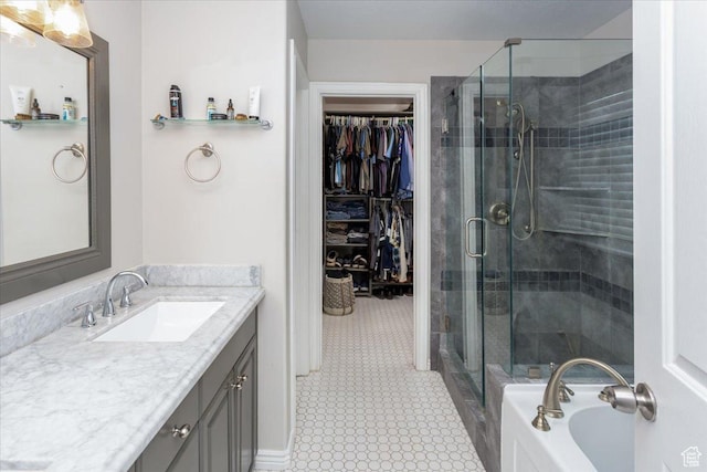 bathroom featuring tile patterned floors, a stall shower, a garden tub, vanity, and a walk in closet