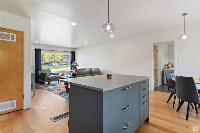 3315 Meadow Dr, Ogden, UT 84403 - kitchen featuring a kitchen island, light wood-type flooring, visible vents, and pendant lighting