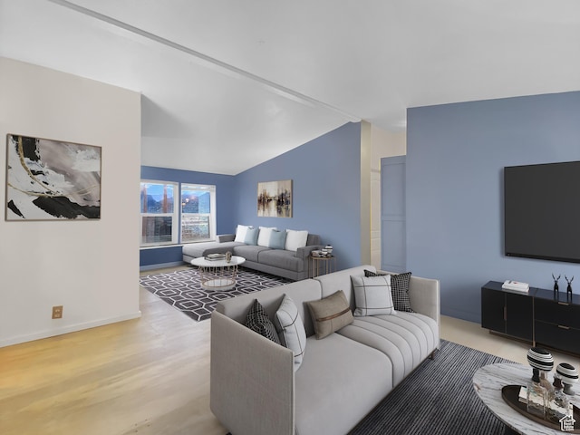 living area with vaulted ceiling, light wood finished floors, and baseboards