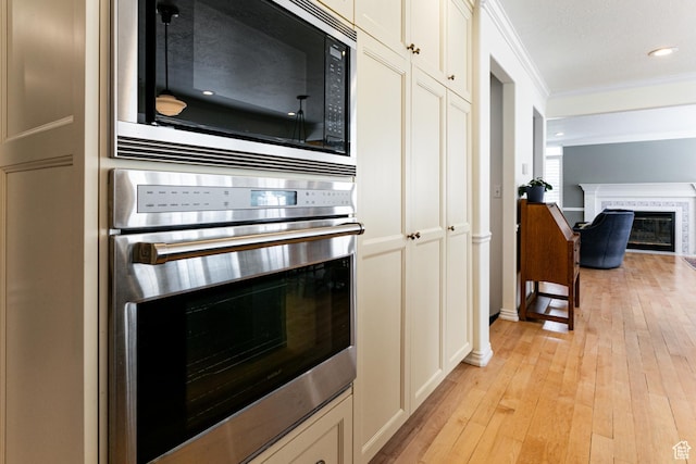 637 S Pine Meadow Ln, Tooele, UT 84074 - kitchen with stainless steel oven, black microwave, ornamental molding, and light wood-style floors