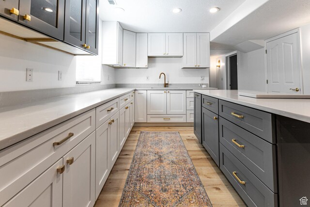 637 S Pine Meadow Ln, Tooele, UT 84074 - kitchen featuring light wood-style flooring, light countertops, and white cabinetry