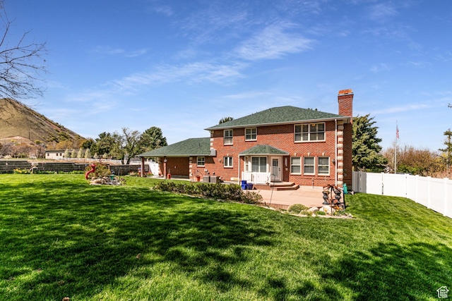 637 S Pine Meadow Ln, Tooele, UT 84074 - back of house with a lawn, a fenced backyard, brick siding, and a patio