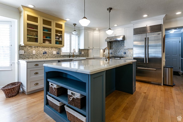 637 S Pine Meadow Ln, Tooele, UT 84074 - kitchen featuring under cabinet range hood, open shelves, stainless steel built in fridge, light wood-type flooring, and crown molding