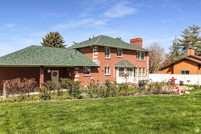 637 S Pine Meadow Ln, Tooele, UT 84074 - back of property with roof with shingles, a chimney, fence, brick siding, and a yard