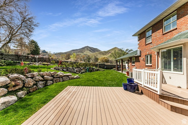 637 S Pine Meadow Ln, Tooele, UT 84074 - wooden terrace with a fenced backyard, a mountain view, and a lawn