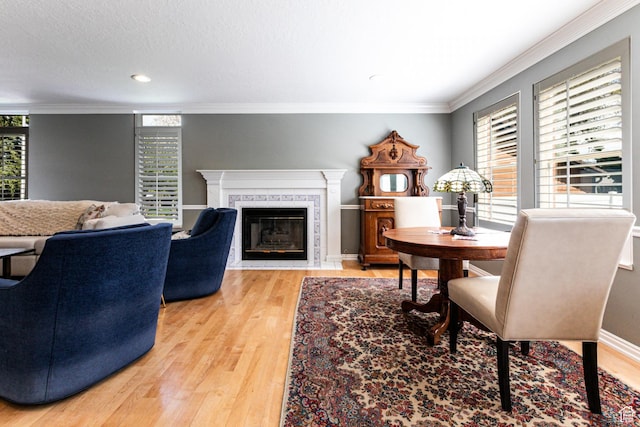 637 S Pine Meadow Ln, Tooele, UT 84074 - dining space with a fireplace with flush hearth, light wood-style flooring, recessed lighting, and crown molding