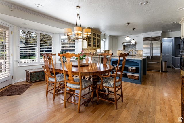 637 S Pine Meadow Ln, Tooele, UT 84074 - dining room with a notable chandelier, a textured ceiling, light wood finished floors, and ornamental molding