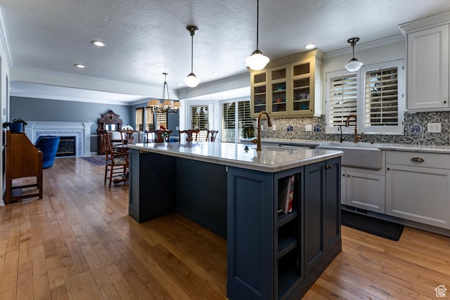 637 S Pine Meadow Ln, Tooele, UT 84074 - kitchen featuring open floor plan, crown molding, a sink, and light wood-type flooring