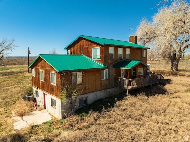 7413 W 7250 S, Myton, UT 84052 - back of house with cooling unit, a chimney, concrete driveway, metal roof, and a deck