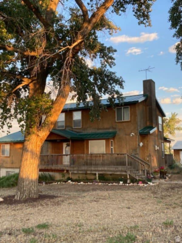 7413 W 7250 S, Myton, UT 84052 - view of front facade with metal roof, a chimney, a standing seam roof, and covered porch