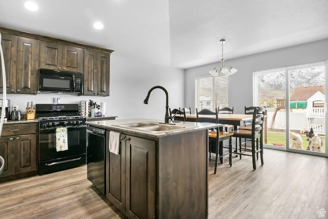 kitchen with light wood-style flooring, a sink, dark brown cabinetry, a chandelier, and black appliances