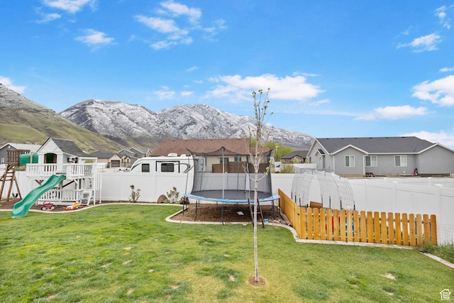 view of yard featuring a fenced backyard, a residential view, and a trampoline