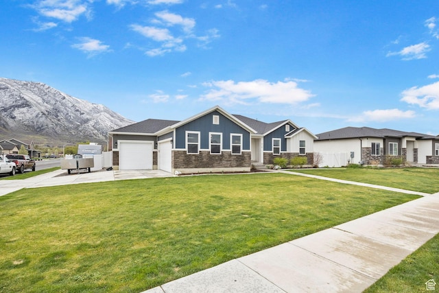 ranch-style house with an attached garage, a front lawn, a mountain view, and concrete driveway