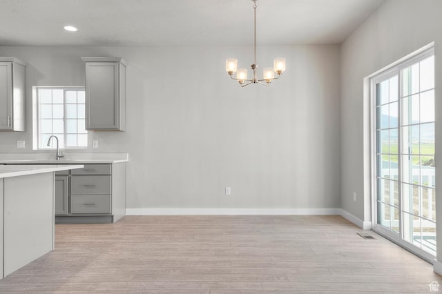 6622 W Spring Snow Ln, Herriman, UT 84096 - unfurnished dining area with light wood-style flooring, healthy amount of natural light, a chandelier, baseboards, and recessed lighting