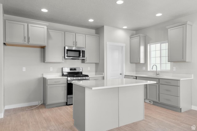 6622 W Spring Snow Ln, Herriman, UT 84096 - kitchen with appliances with stainless steel finishes, a sink, gray cabinetry, baseboards, and light wood-type flooring