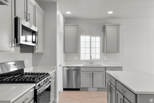 6622 W Spring Snow Ln, Herriman, UT 84096 - kitchen featuring appliances with stainless steel finishes, a sink, gray cabinetry, light countertops, and recessed lighting