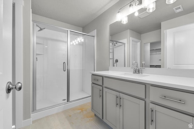 6622 W Spring Snow Ln, Herriman, UT 84096 - bathroom featuring a stall shower, vanity, a spacious closet, and a textured ceiling