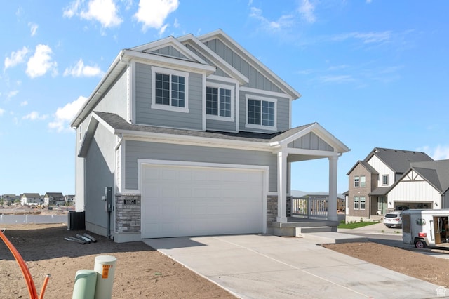 6622 W Spring Snow Ln, Herriman, UT 84096 - view of front of property featuring an attached garage, board and batten siding, concrete driveway, stone siding, and a porch