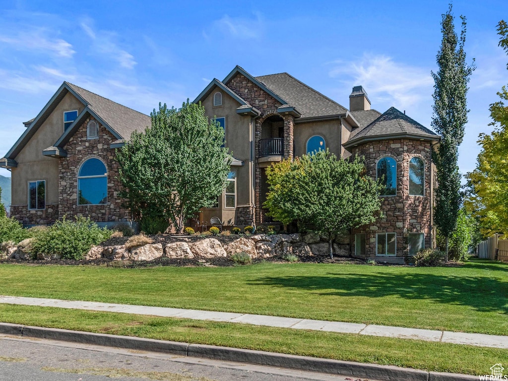 337 W Paddock Ln S, Kaysville, UT 84037 - view of front of house with a chimney, a front yard, a balcony, stone siding, and stucco siding
