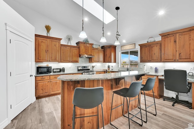 4990 W 12000 N, Tremonton, UT 84337 - kitchen featuring stainless steel range with gas stovetop, a center island, light wood-style floors, lofted ceiling, and black microwave