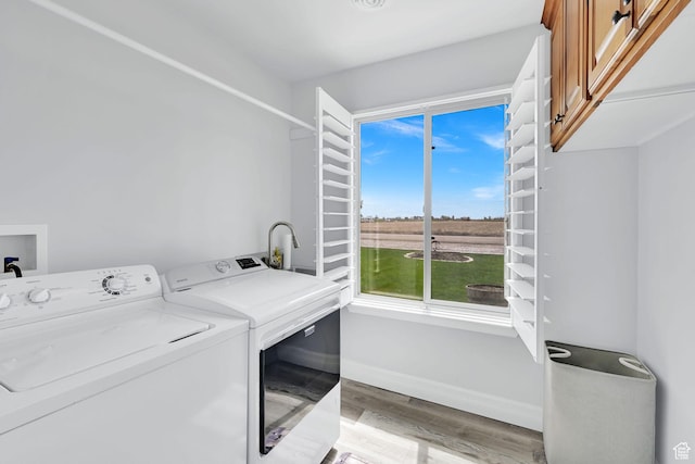 4990 W 12000 N, Tremonton, UT 84337 - laundry area featuring washer and dryer, baseboards, cabinet space, and light wood-type flooring