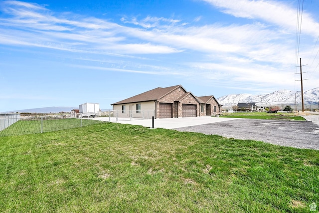 4990 W 12000 N, Tremonton, UT 84337 - exterior space featuring driveway, fence, a mountain view, and a garage