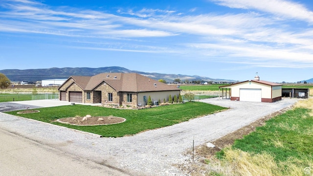 4990 W 12000 N, Tremonton, UT 84337 - ranch-style home with an outbuilding, a front lawn, a mountain view, a detached garage, and fence