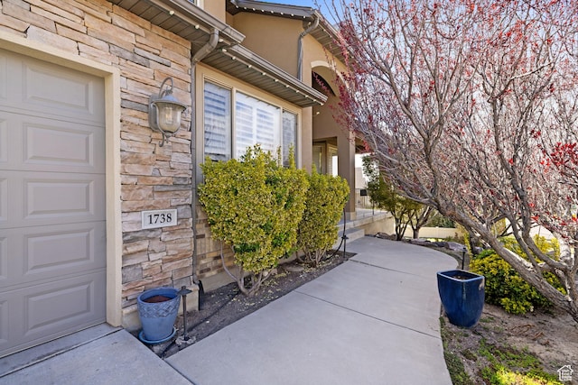 property entrance featuring stucco siding and stone siding