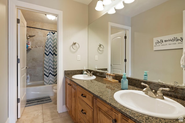 full bathroom with double vanity, tile patterned floors, toilet, and a sink