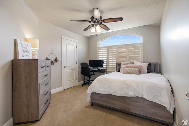 bedroom featuring light colored carpet, ceiling fan, and baseboards