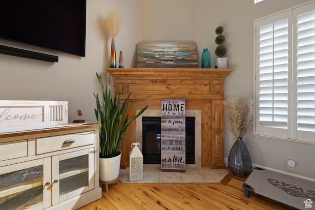 interior space with wood finished floors and a tile fireplace