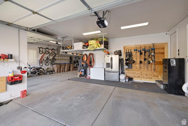 garage with stainless steel fridge and a garage door opener