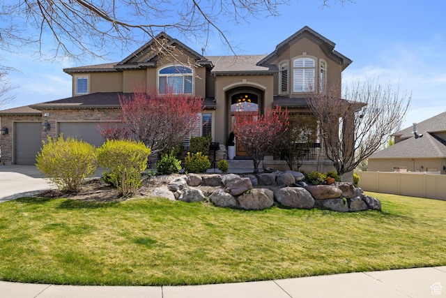 view of front of house with fence, a front lawn, concrete driveway, stucco siding, and a garage