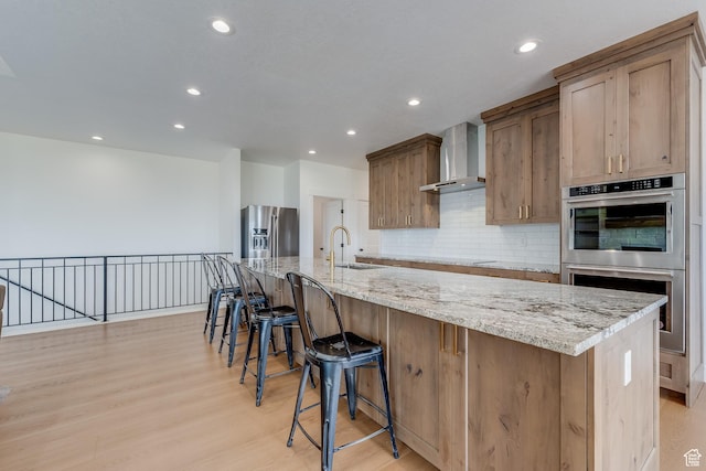 1993 S 5000 W, Taylor, UT 84401 - kitchen with light wood-style flooring, backsplash, wall chimney exhaust hood, appliances with stainless steel finishes, and recessed lighting
