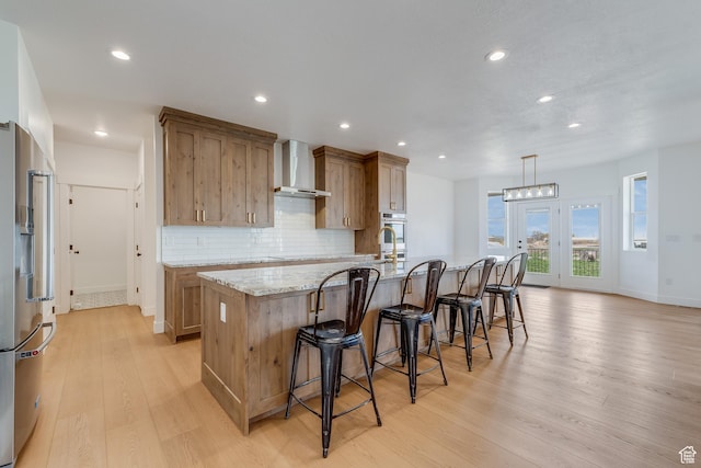 1993 S 5000 W, Taylor, UT 84401 - kitchen featuring a large island with sink, light wood-style floors, wall chimney exhaust hood, appliances with stainless steel finishes, and recessed lighting